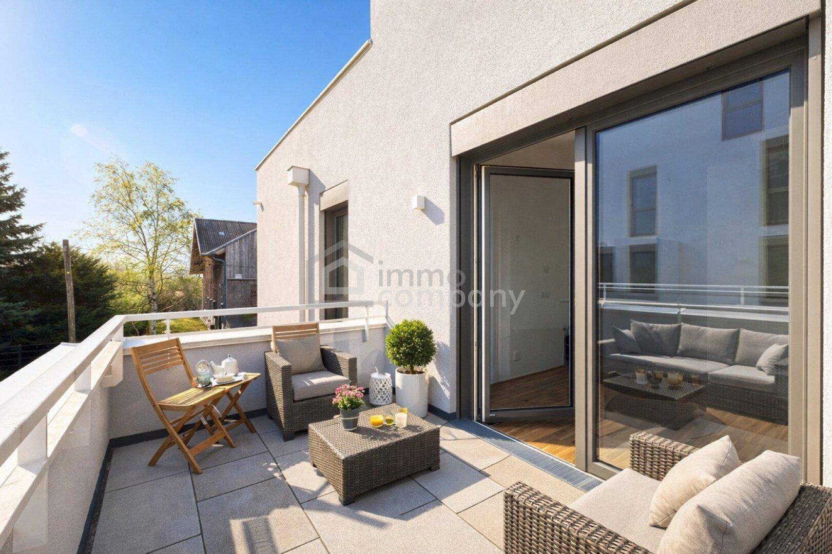 Sonniger Balkon mit bequemen Gartenmöbeln und Blick ins Grüne, ideal zum Entspannen im Freien.