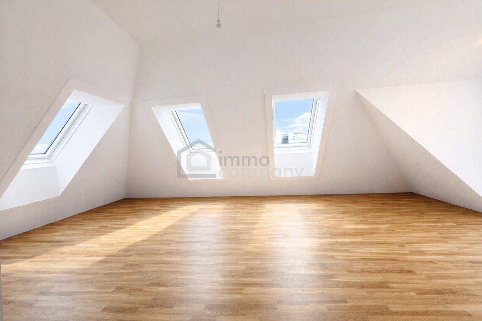 Leerer Raum im Dachgeschoss mit schrägen Wänden, Dachfenstern und Holzboden.