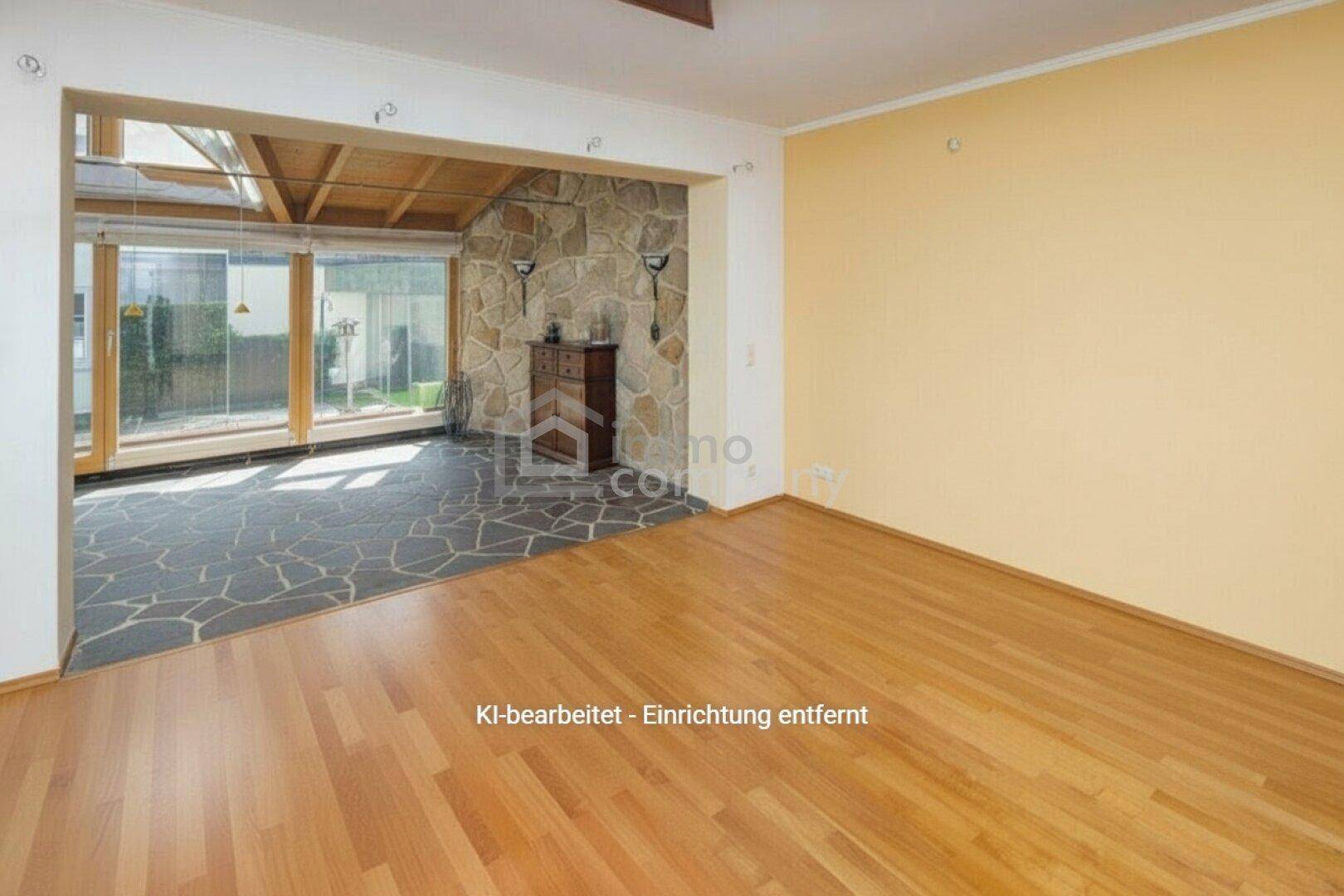 Geräumiger Wohnbereich mit Holzboden, der in einen hellen Raum mit Steinwand und großen Fenstern übergeht.