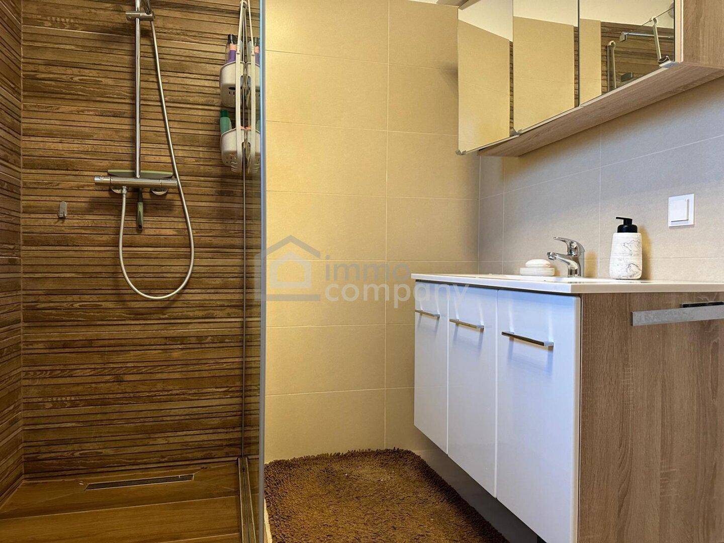 Modernes Badezimmer mit begehbarer Dusche, Holzoptikfliesen und Einzelwaschbecken.