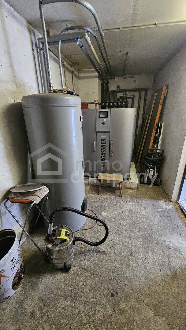 Heizungsraum mit großem Warmwasserspeicher und Heizkessel.