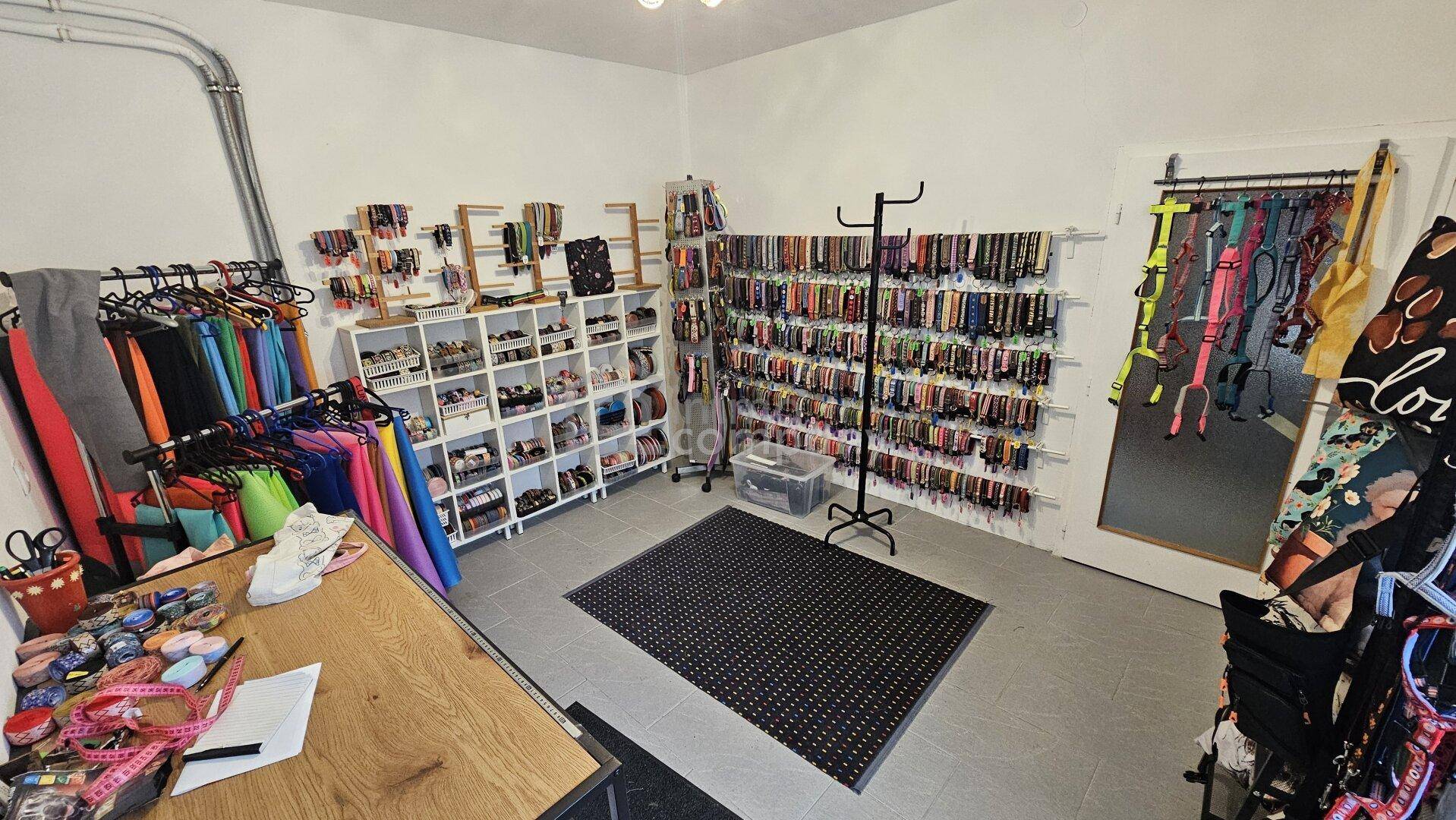 Verkaufs- oder Arbeitsraum mit Regalen voller Produkte und einem großen Teppich.