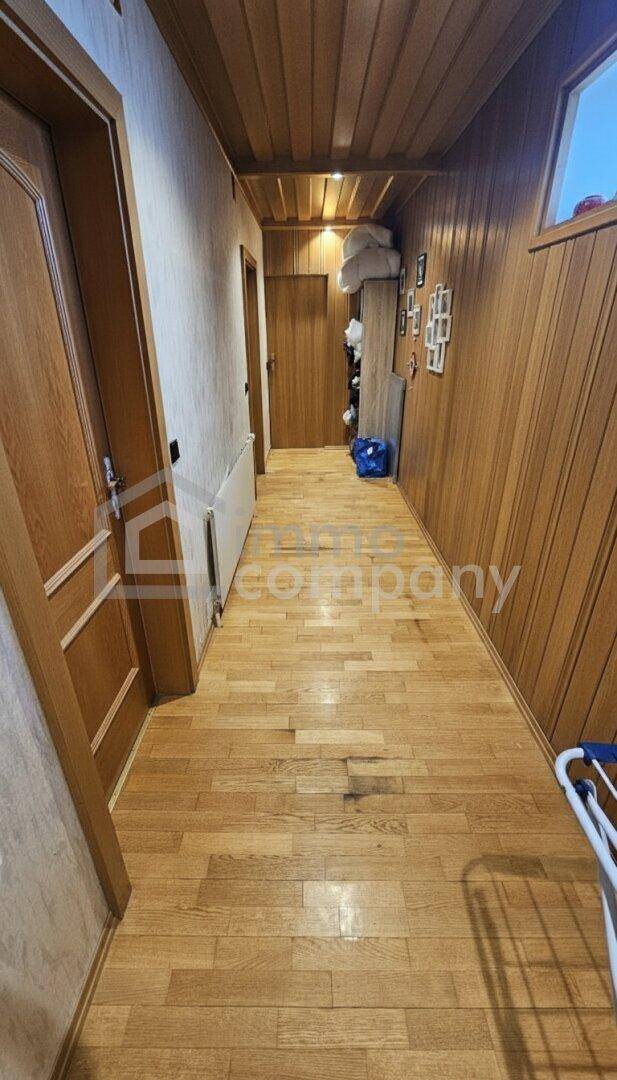 Langer Flur mit Holzvertäfelung an Wänden und Decke sowie Holzboden.