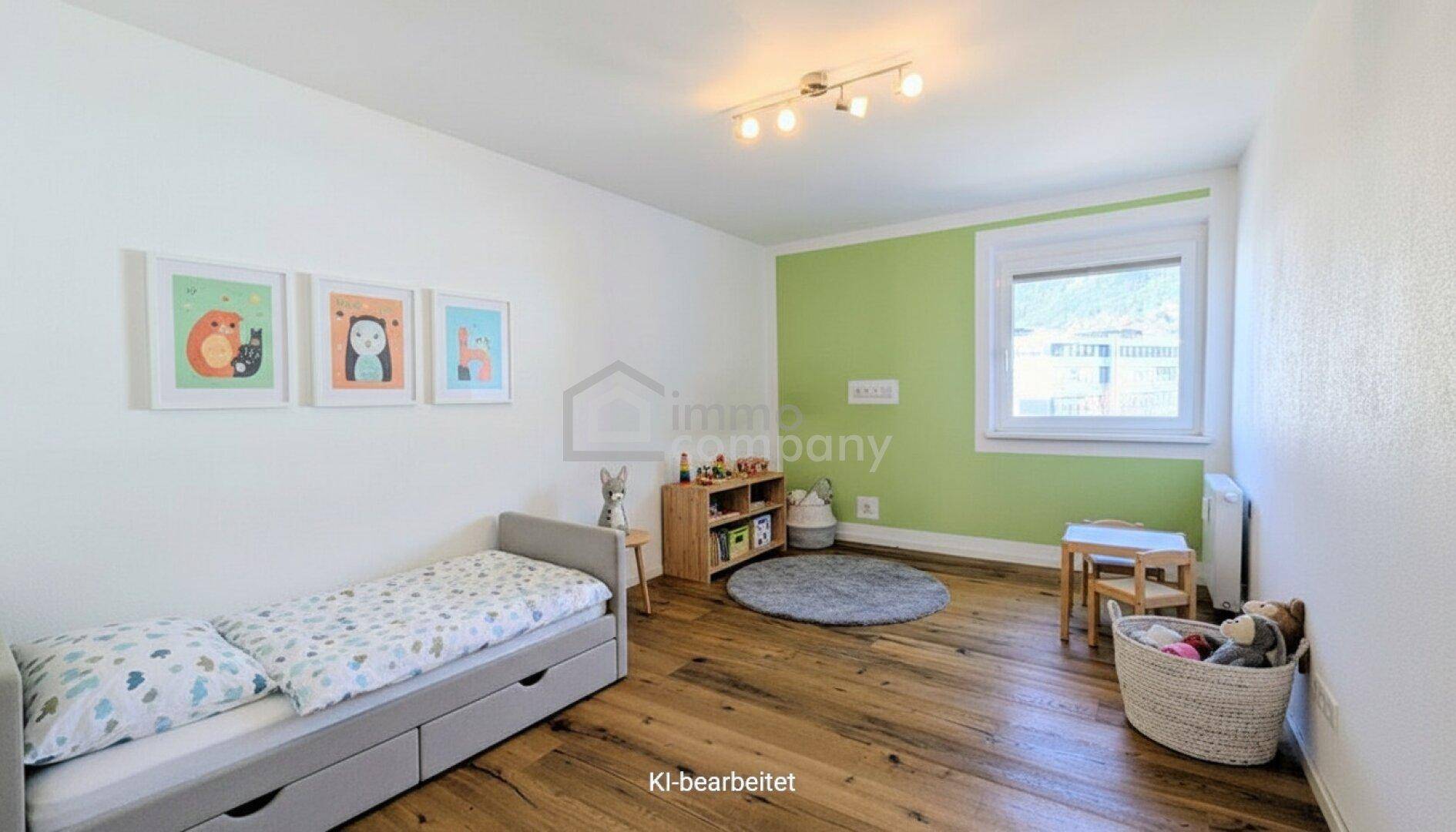 Freundliches Kinderzimmer mit Holzboden, grüner Akzentwand und kindgerechter Einrichtung.