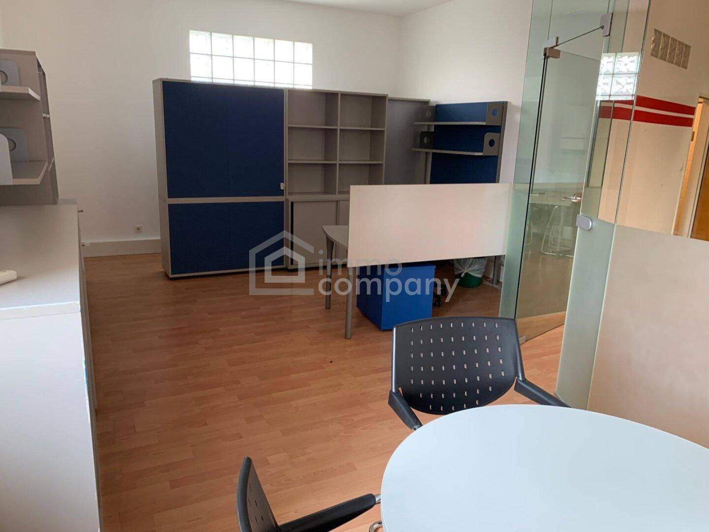 Offener Bürobereich mit flexiblen Möbeln, Glasbausteinen und viel Stauraum in Regalen.