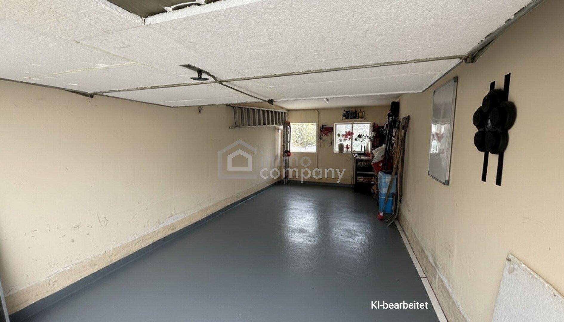 Geräumige Garage mit Betonboden und Fenstern, bereit für Fahrzeuge oder Lagerung.