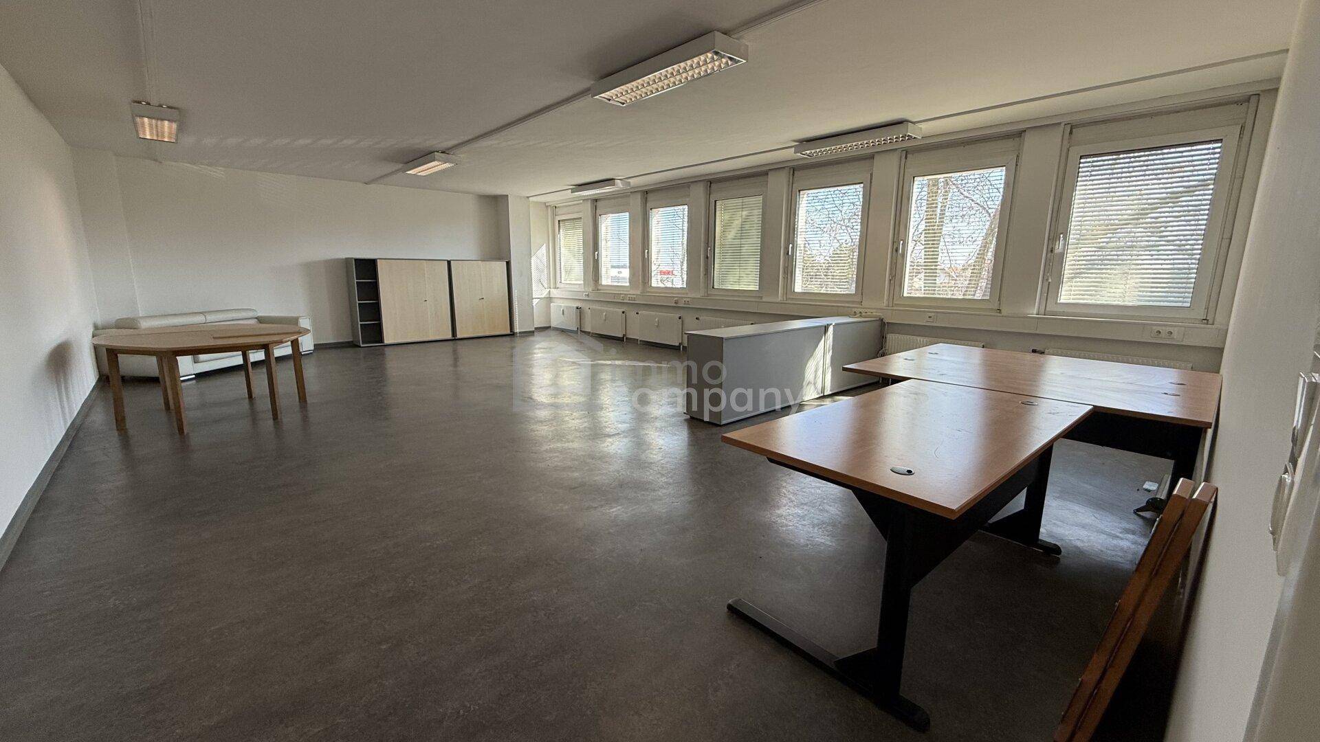 Leeres Großraumbüro mit großen Fenstern und Heizkörpern, bereit für neue Einrichtung und Nutzung.