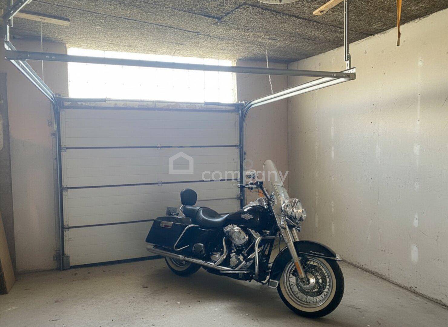 Geräumige Garage mit Sektionaltor und ausreichend Platz für Fahrzeuge.