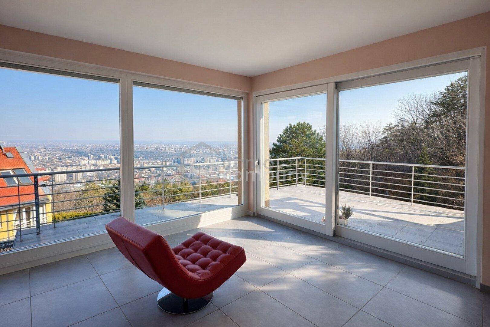 Helles Wohnzimmer mit großen Schiebefenstern, Fliesenboden und weitem Stadtblick.