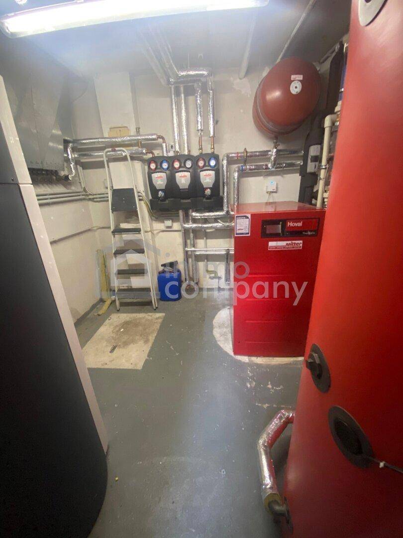 Technikraum mit Heizungsanlage und Warmwasserspeicher.