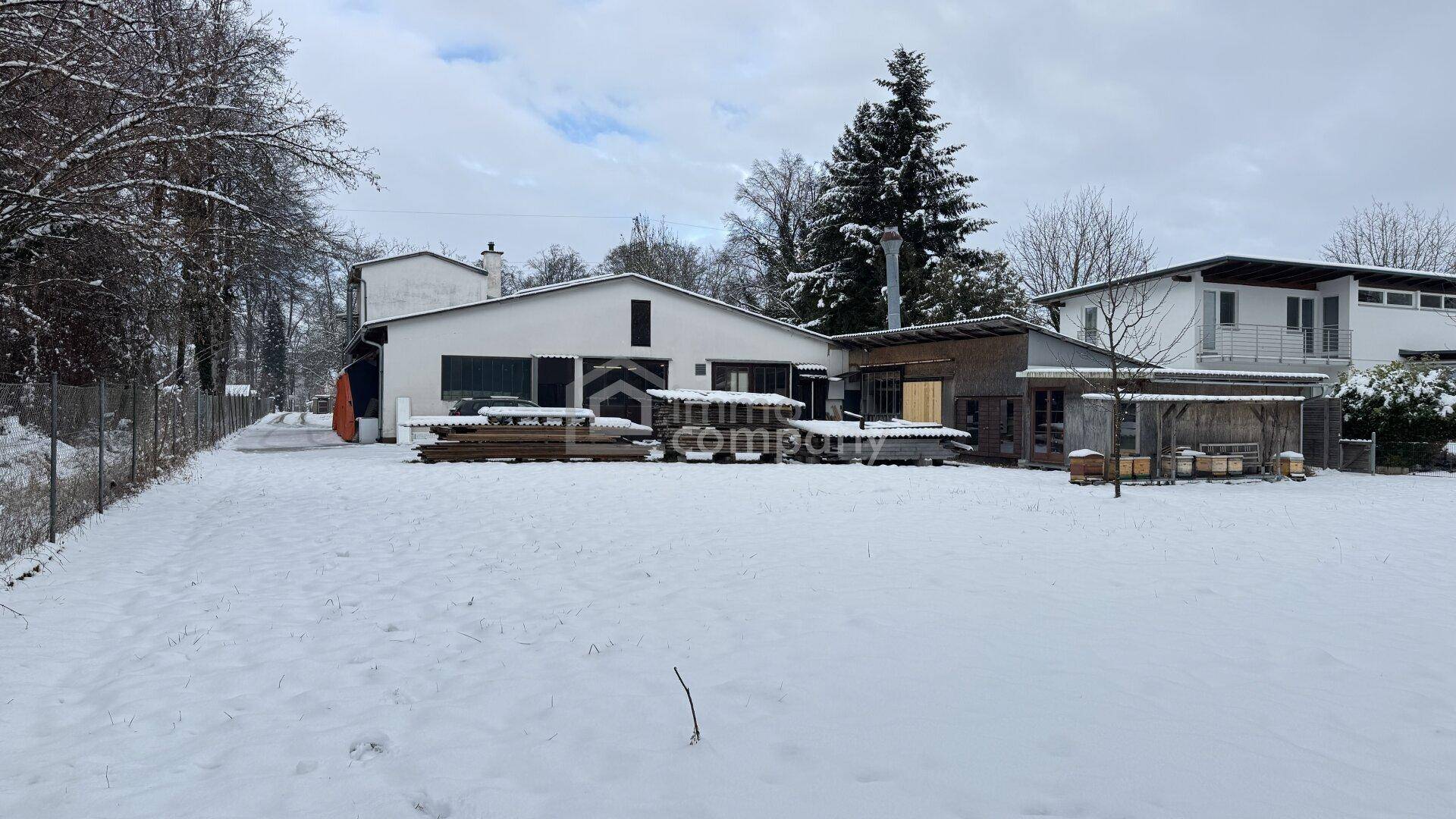 Rückansicht der Gebäude in einer verschneiten Winterlandschaft mit Bäumen.