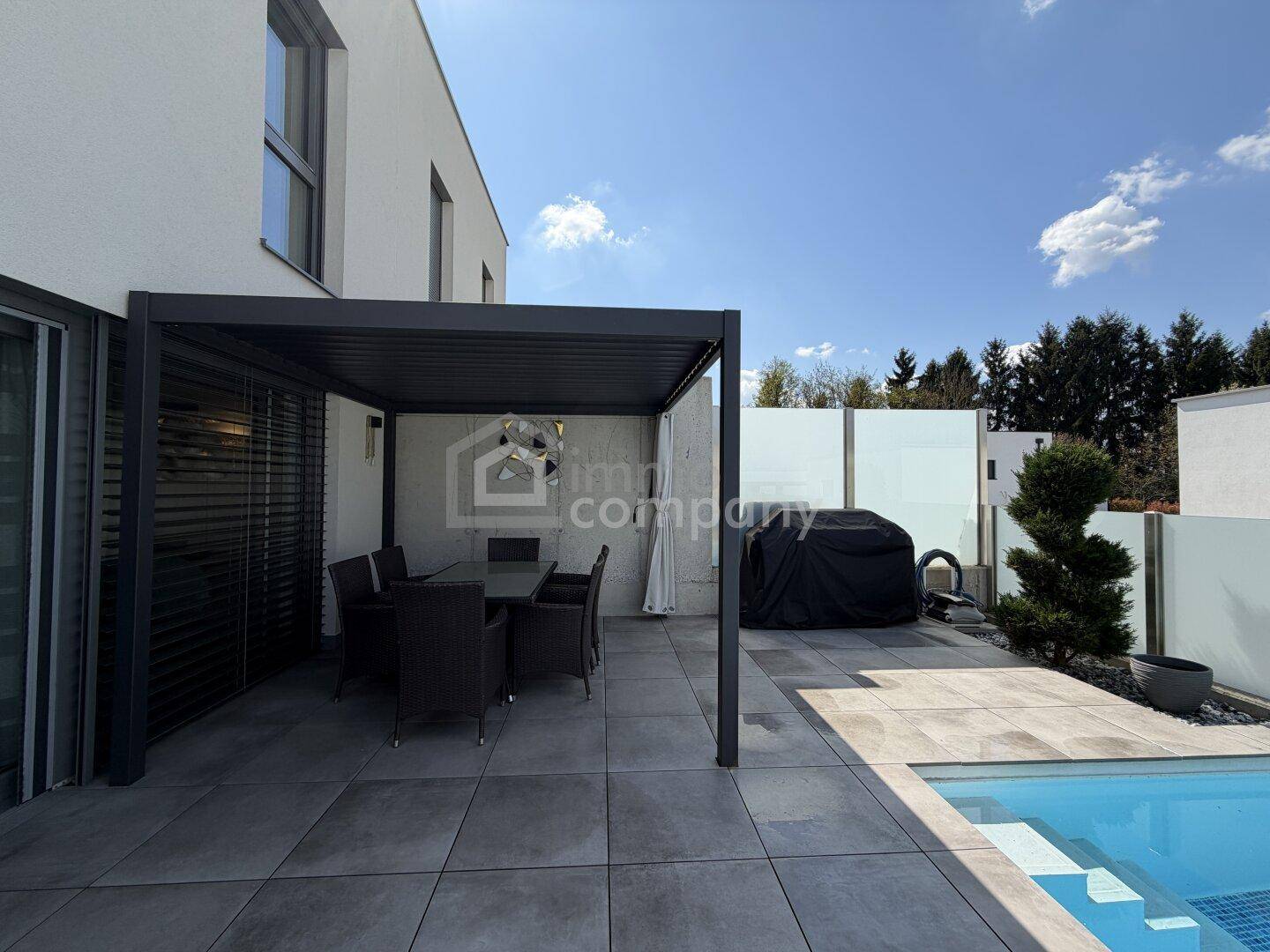 Sonniger Terrassenbereich mit Pergola, Esstisch und direktem Zugang zum Pool.