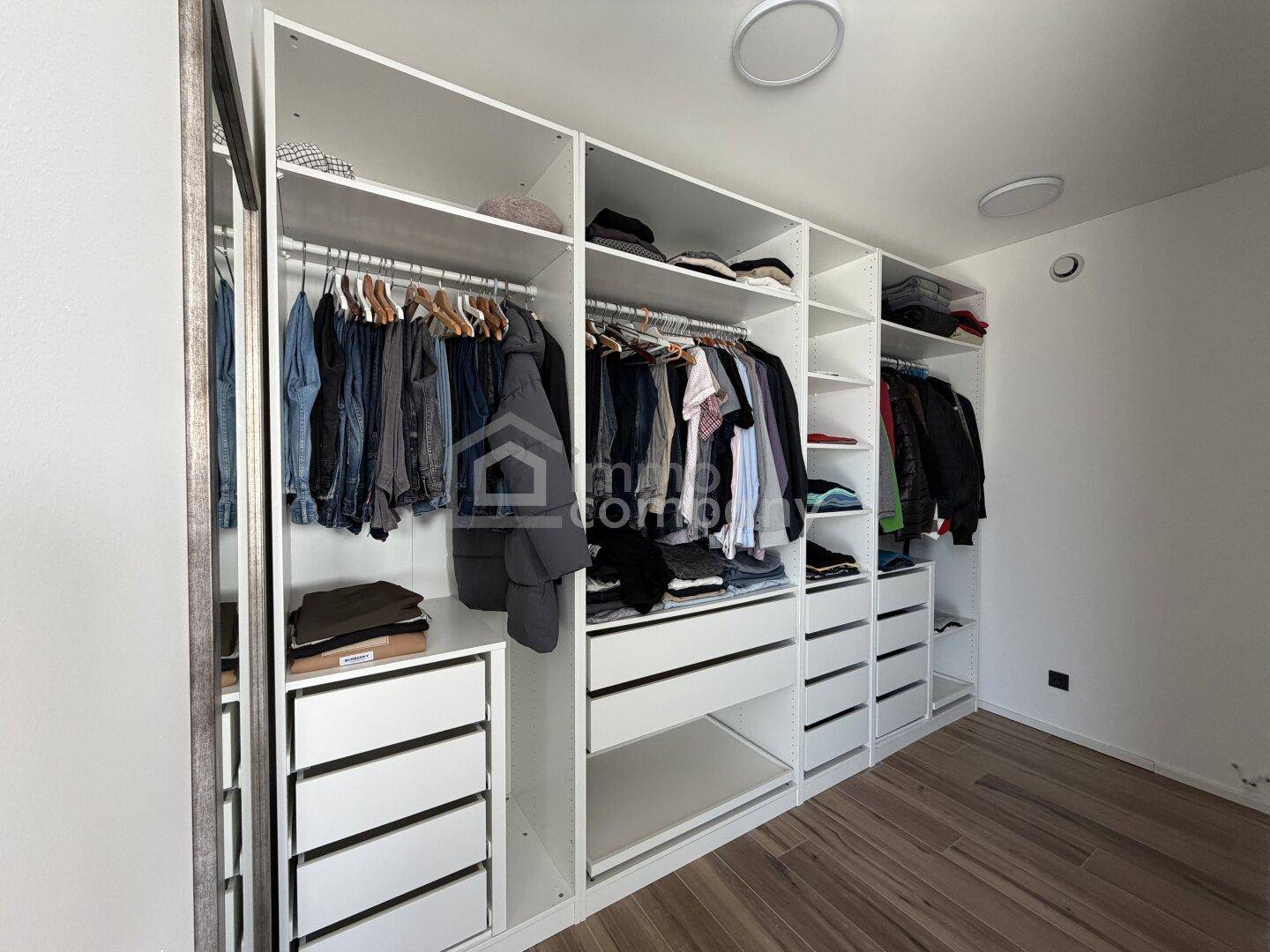 Geräumiger begehbarer Kleiderschrank mit vielen Fächern und Hängemöglichkeiten.