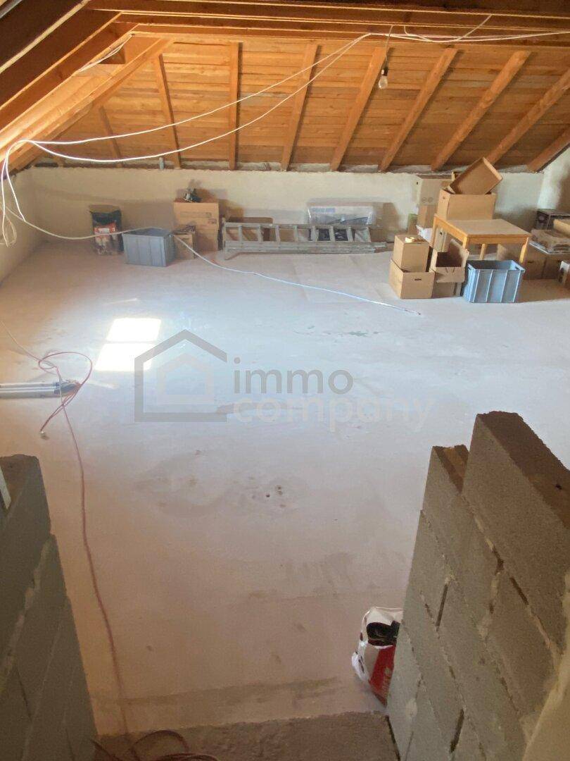 Unausgebauter Dachboden mit sichtbaren Holzbalken, bietet Potenzial für zukünftige Nutzung.