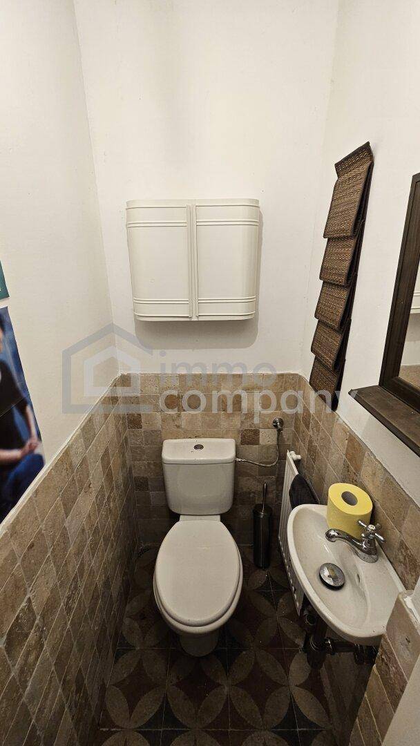 Kleines Gäste-WC mit Fliesenboden und gemusterten Wandfliesen.