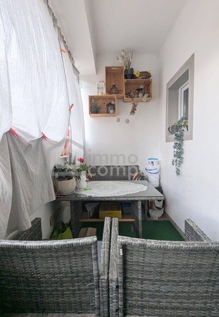 Gemütliche Loggia mit Sitzgelegenheiten und dekorativen Elementen, ideal für entspannte Stunden.