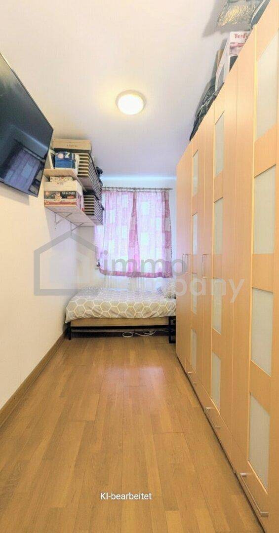 Schmaler Raum mit Einzelbett und langer Schrankwand, ideal als Gästezimmer oder Kinderzimmer.