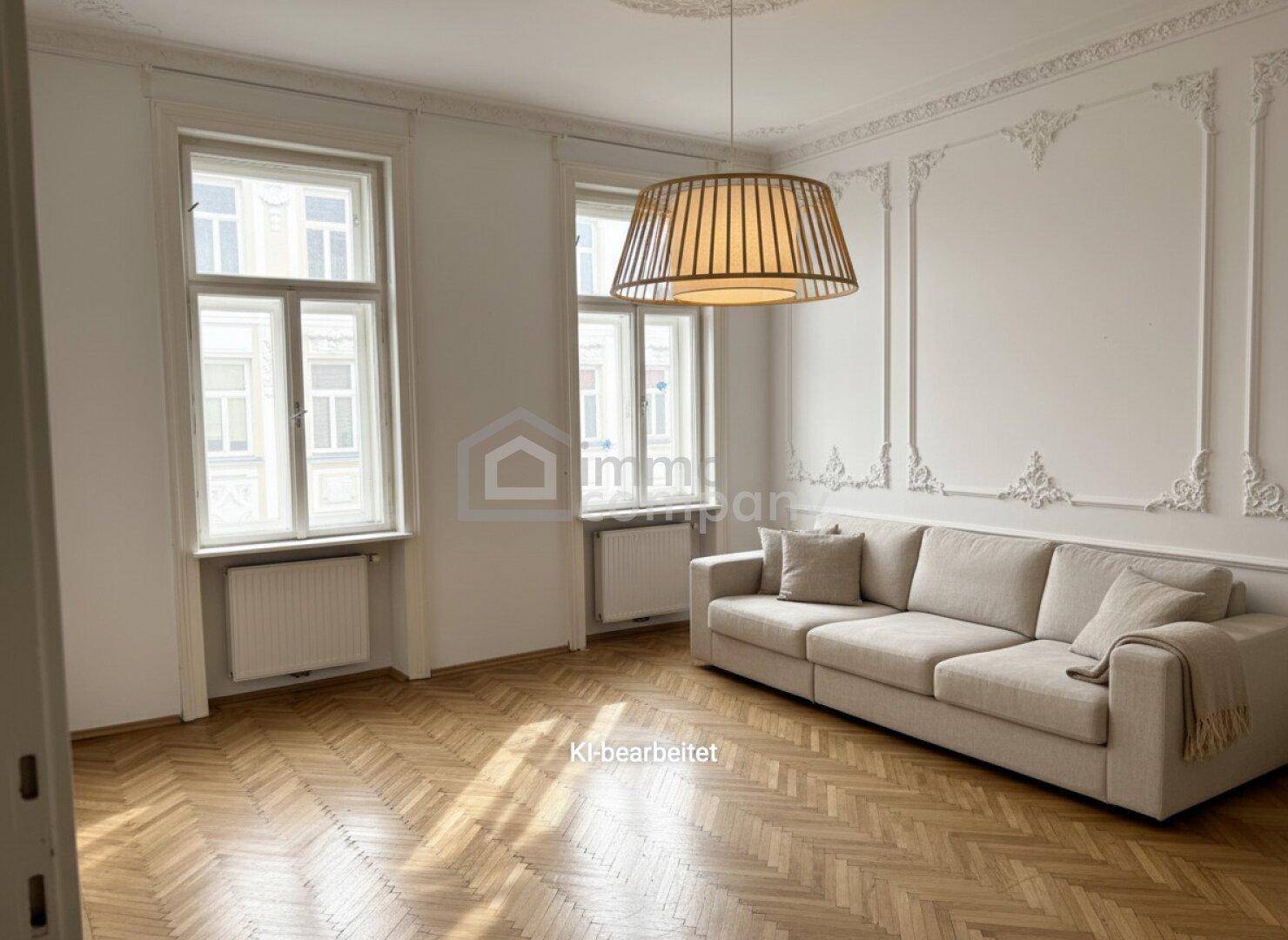 Stilvolles Wohnzimmer mit Stuckdecke, Fischgrätparkett und einem modernen Sofa.