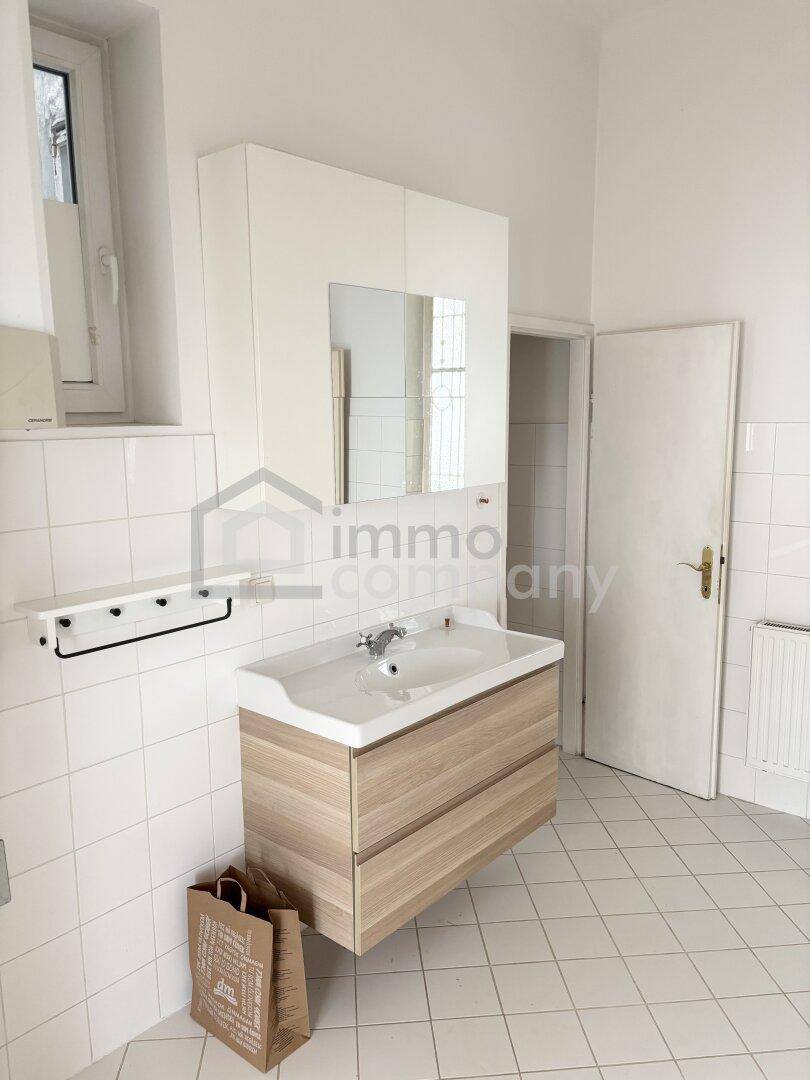 Modernes Badezimmer mit Waschtischunterschrank, Spiegelschrank und Fenster für Tageslicht.