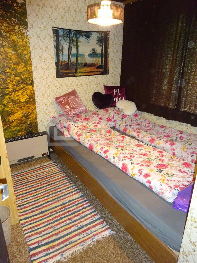 Schlafzimmer mit zwei Einzelbetten, floraler Bettwäsche und gemusterten Tapeten, bietet eine gemütliche Atmosphäre.