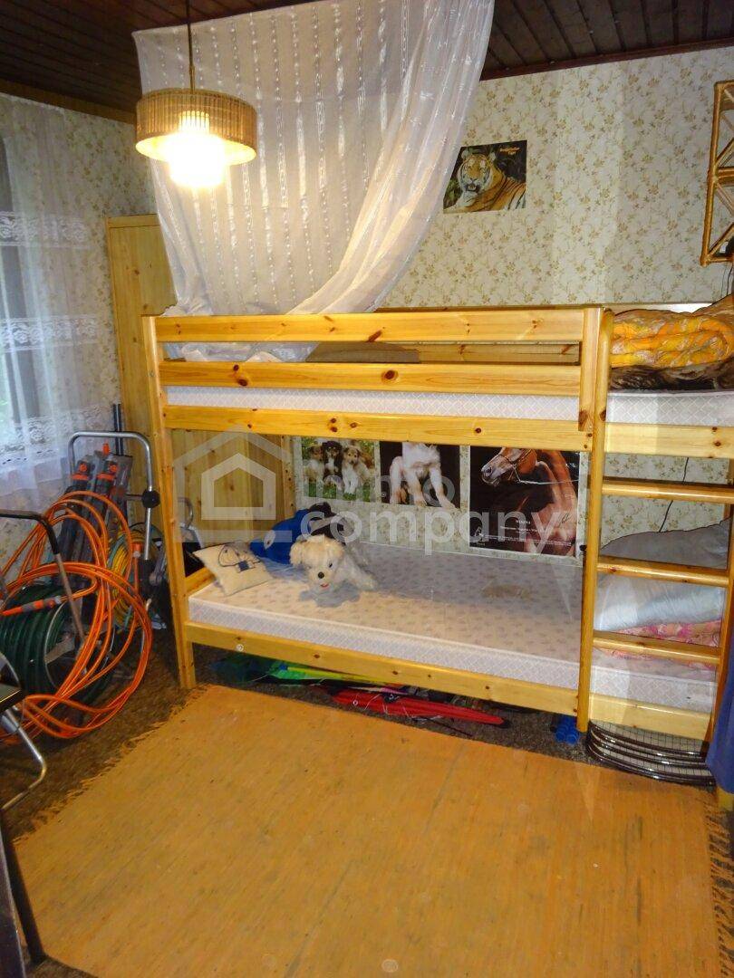 Kinderzimmer mit einem stabilen Holz-Etagenbett und gemusterter Tapete, bietet Platz für zwei Personen.