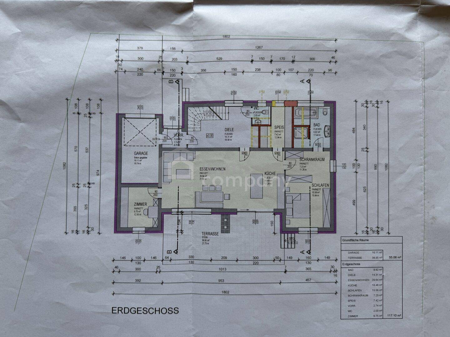 Grundriss des Erdgeschosses mit Wohnbereich, Küche, Terrasse und Garage, inklusive Maßen.