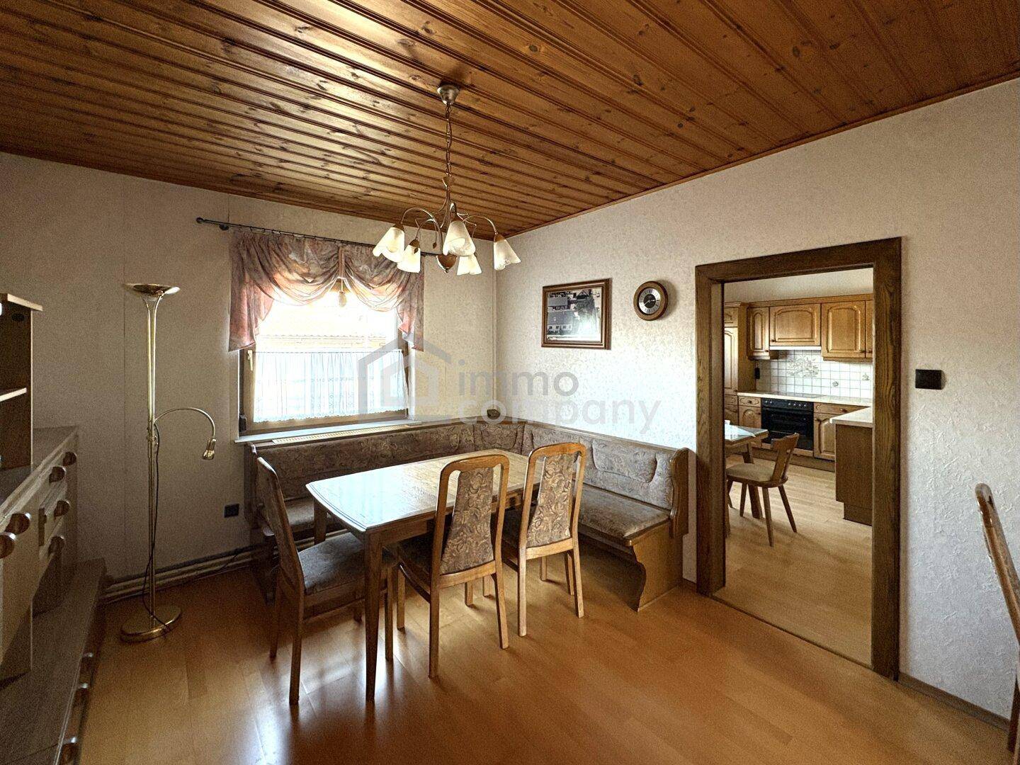 Traditioneller Essbereich mit Holztisch, Eckbank und Zugang zur angrenzenden Küche.