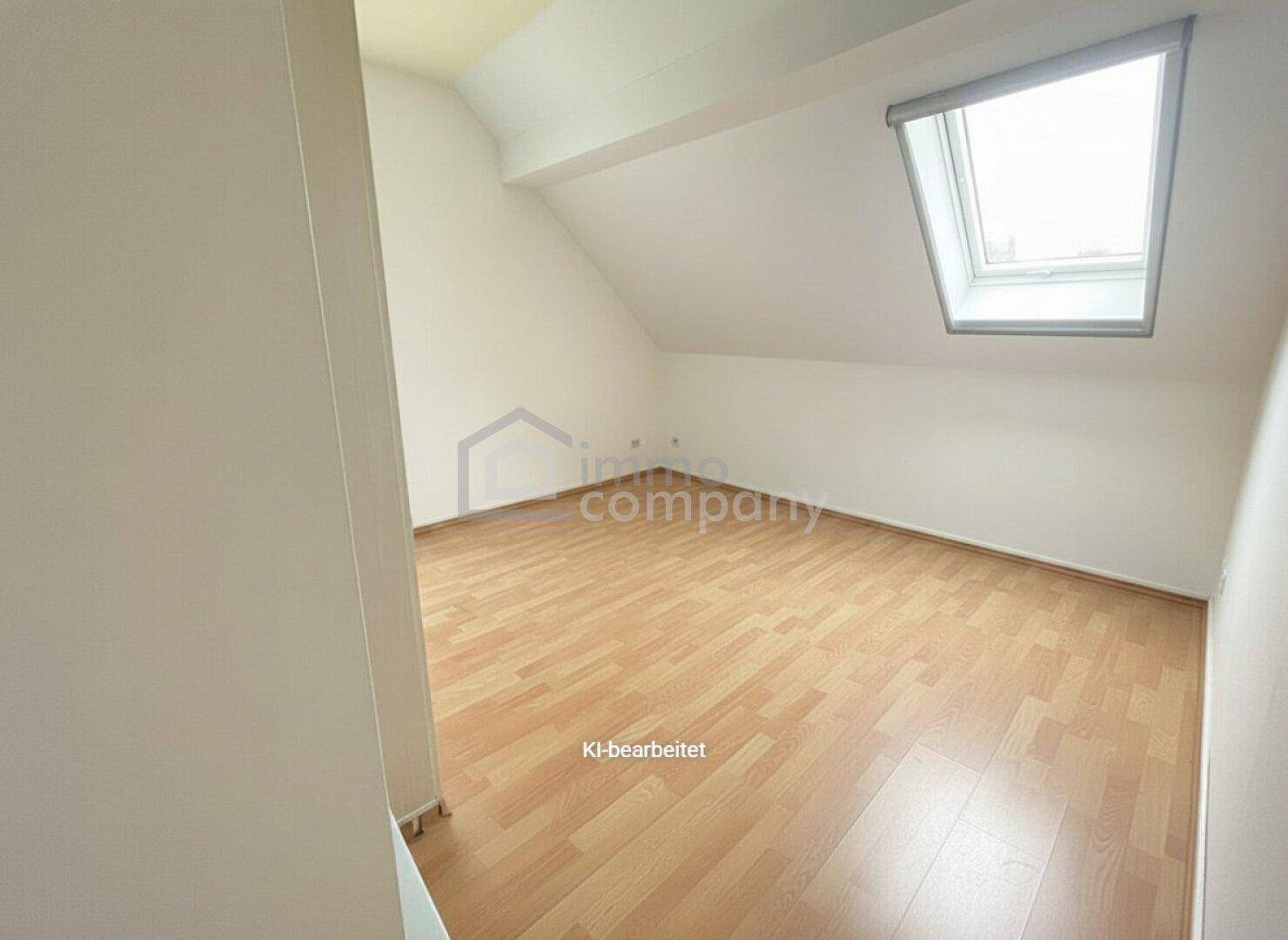 Leerer Raum mit Holzboden, Dachschrägen und Dachfenster, bereit zur individuellen Gestaltung.