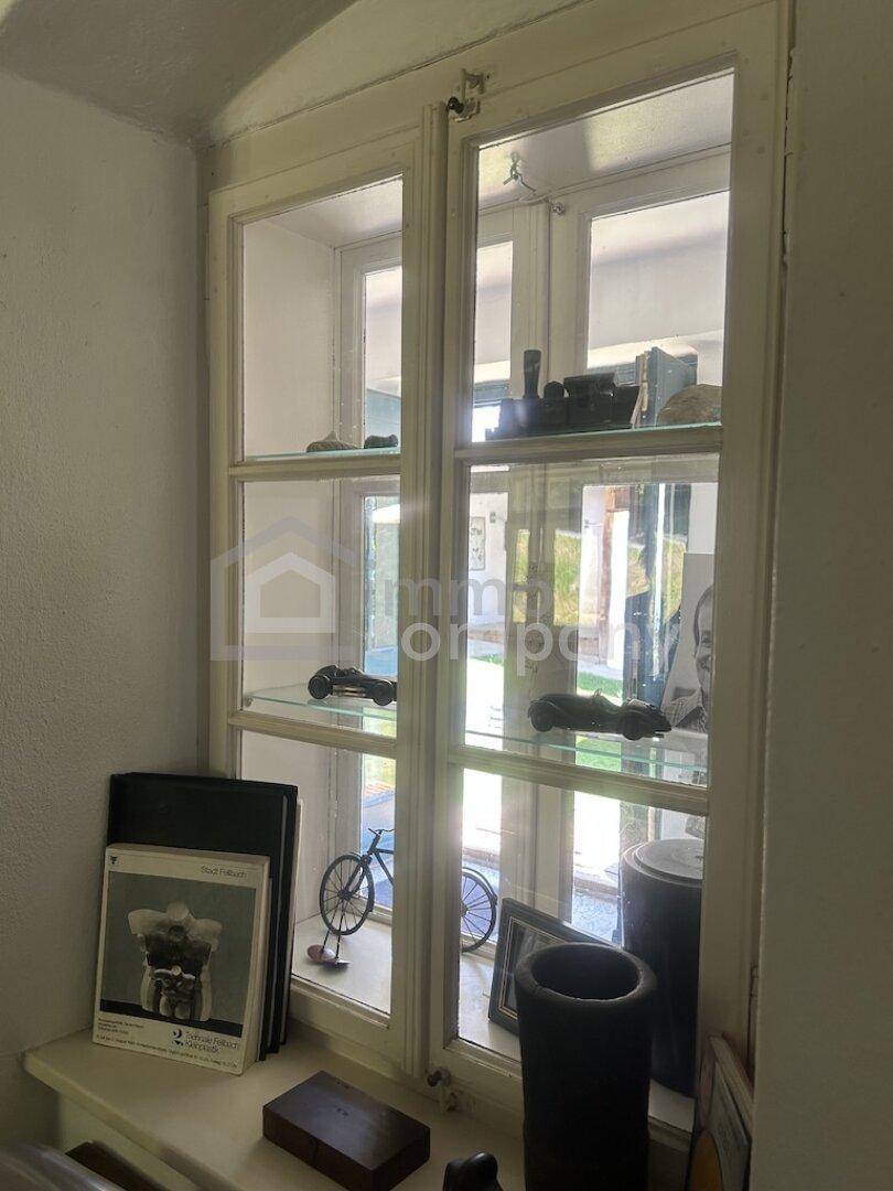 Fenster mit Sprossen und dekorativen Objekten, die das natürliche Licht hereinlassen.