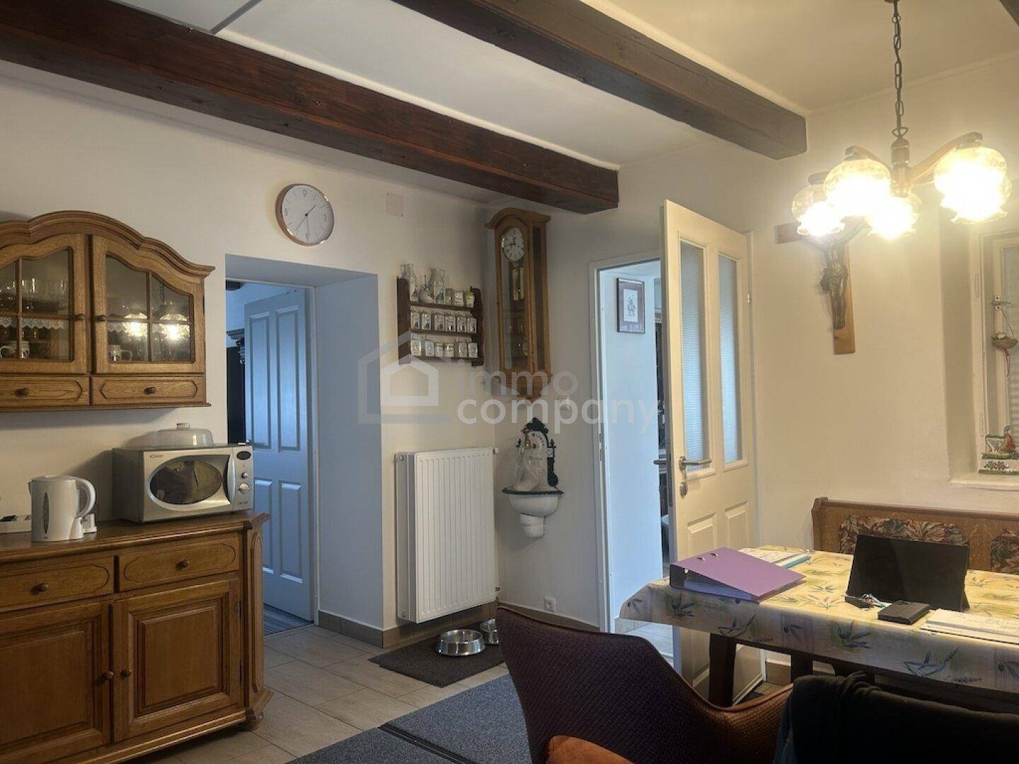 Essbereich mit Holztisch, traditionellen Möbeln und sichtbaren Deckenbalken, angrenzend an die Küche.