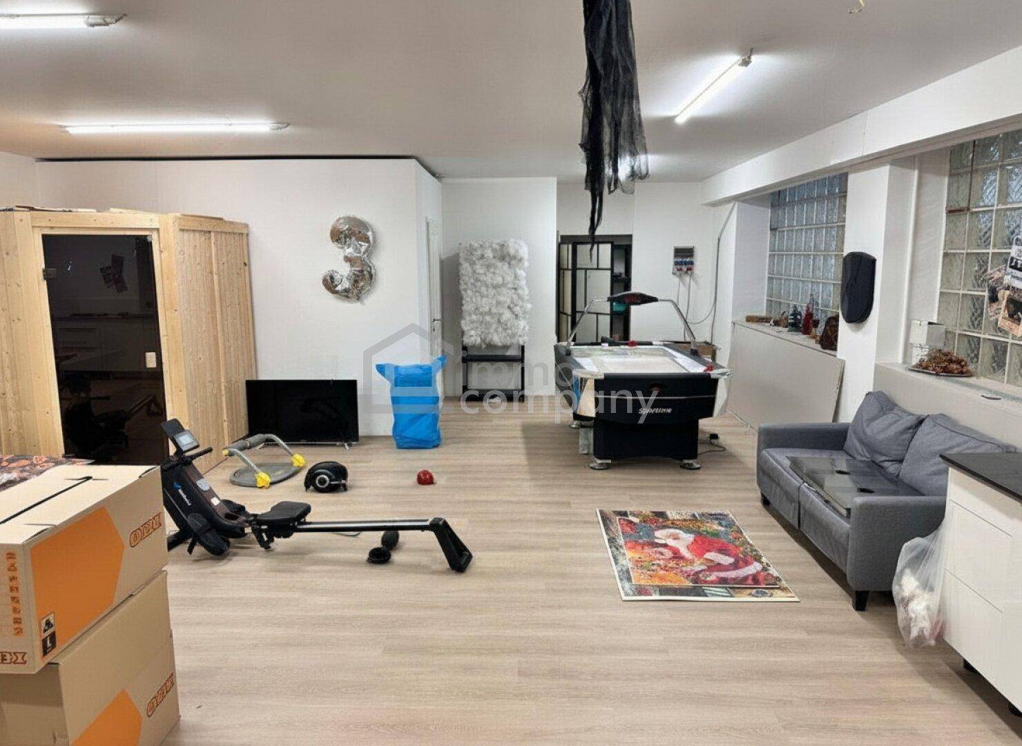 Großer Mehrzweckraum im Untergeschoss mit Sauna, Rudergerät und Billardtisch.