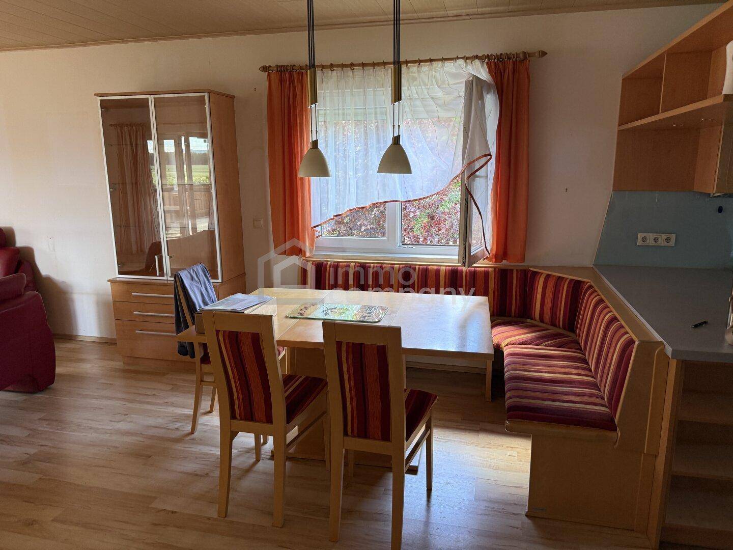 Gemütlicher Essbereich mit Holztisch, Eckbank und Blick in den Garten.