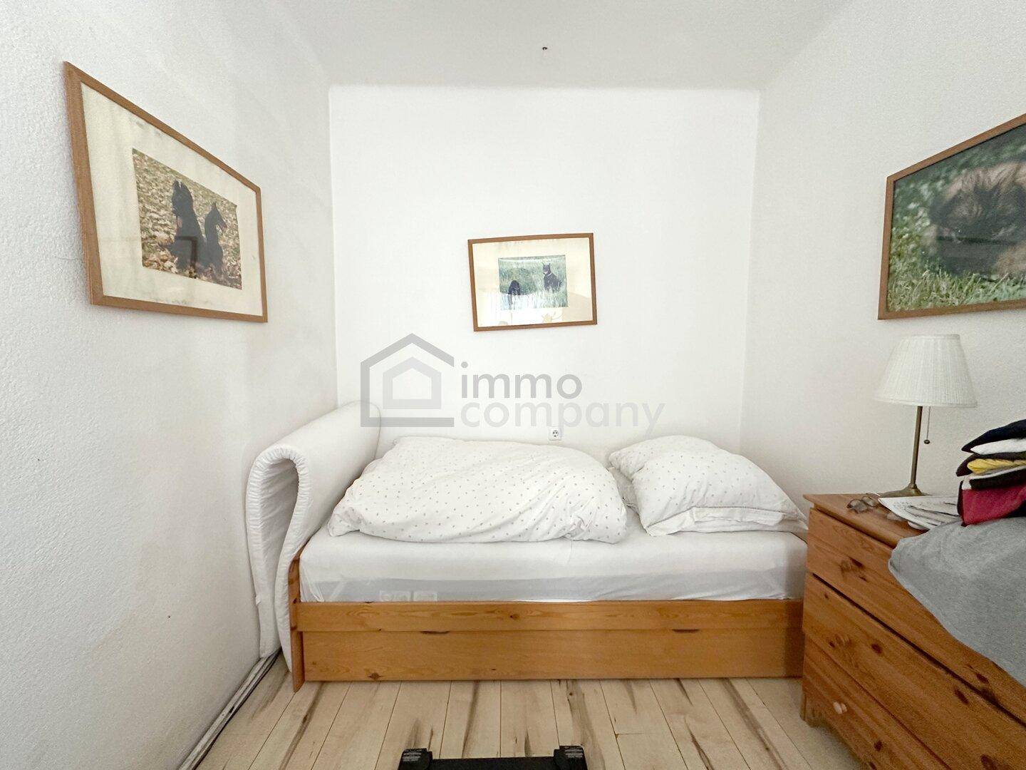 Kleines Schlafzimmer mit Einzelbett und Holzboden, hell und einfach eingerichtet.