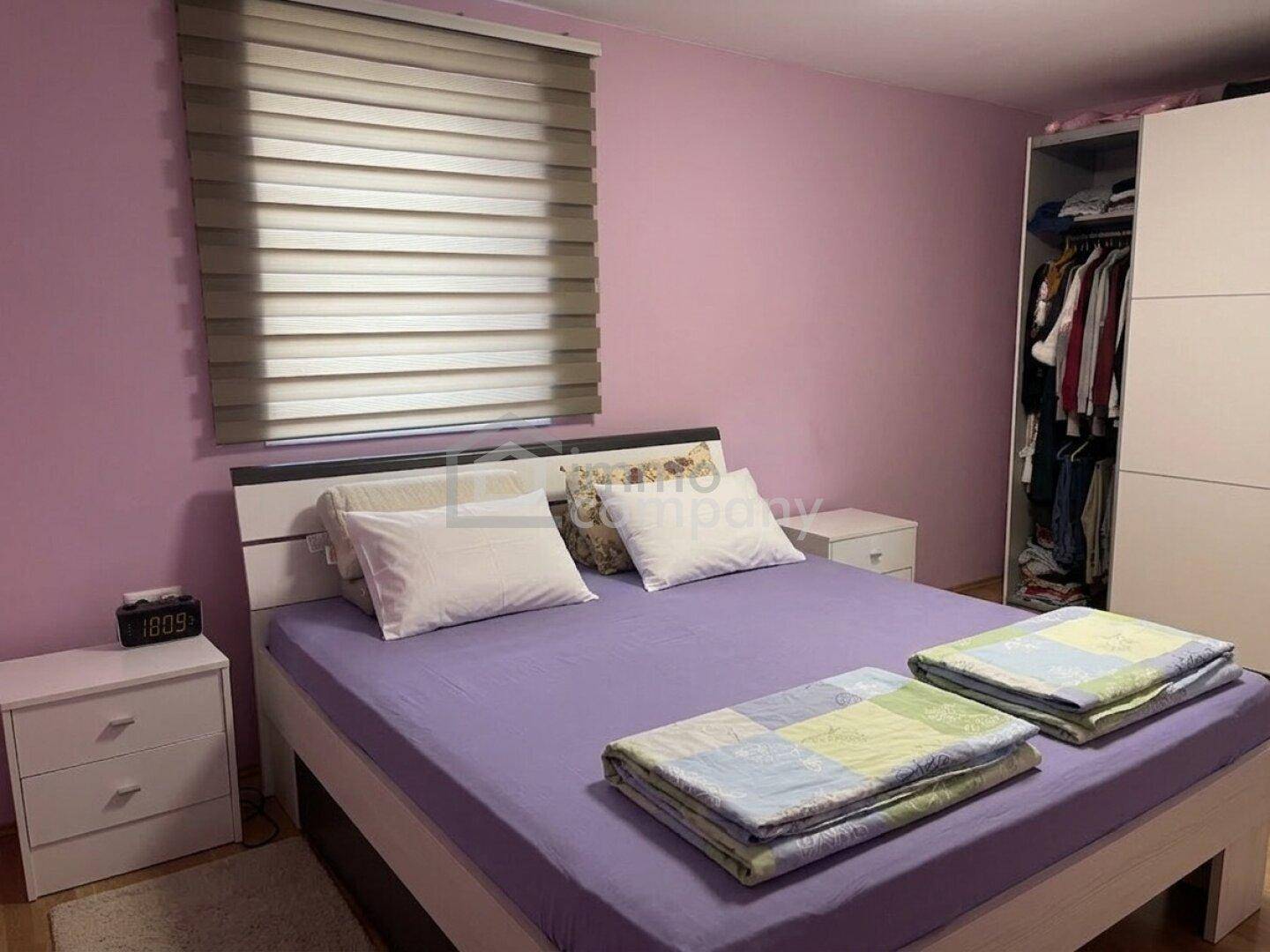 Gemütliches Schlafzimmer mit Doppelbett, Nachttischen und einem Kleiderschrank.