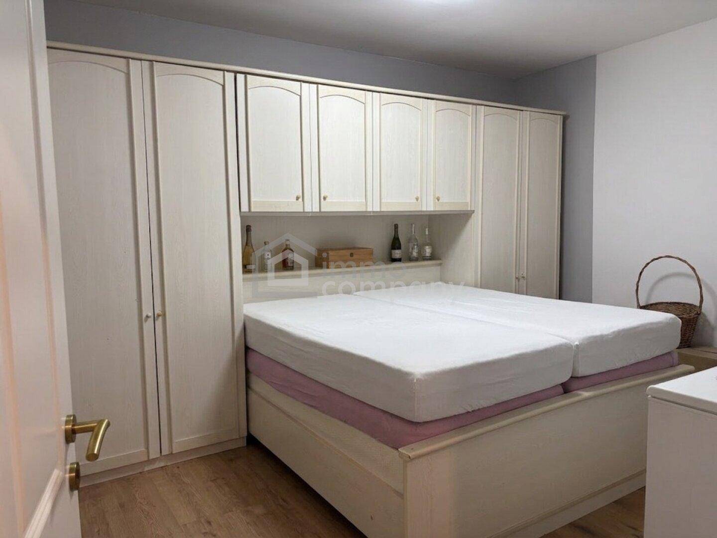 Schlafzimmer mit Doppelbett und praktischen Einbauschränken für Stauraum.