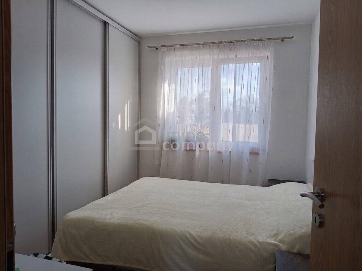 Gemütliches Schlafzimmer mit Doppelbett, großem Schiebeschrank und Fenster.