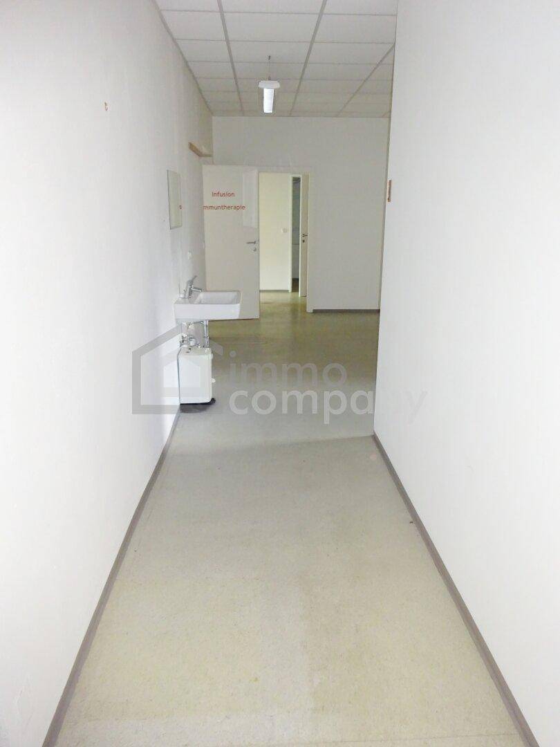 Langer, heller Flur mit Waschbecken und Zugang zu weiteren Räumen.