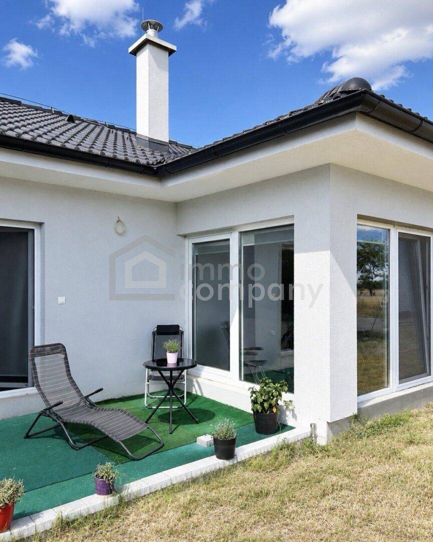 Kleine Terrasse mit Liegestuhl und Pflanzen, ideal für entspannte Stunden im Freien.
