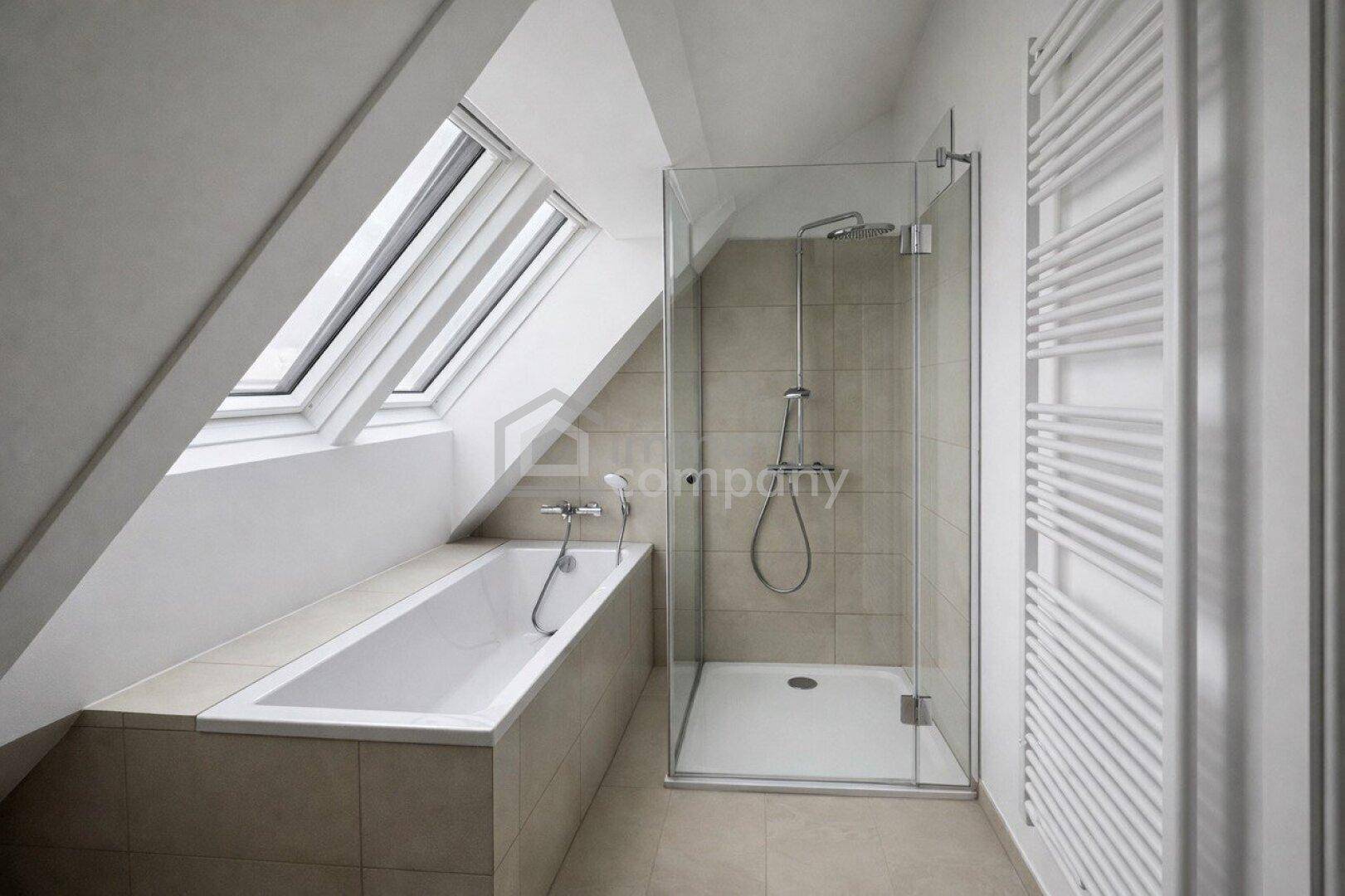 Modernes Badezimmer im Dachgeschoss mit Badewanne, Dusche, Handtuchheizkörper und Dachfenster.