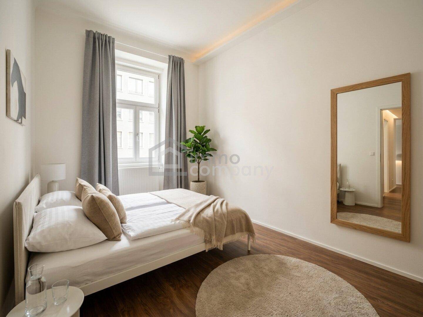 Ruhiges Schlafzimmer mit Doppelbett, großem Spiegel und Blick aus dem Fenster auf die Umgebung.