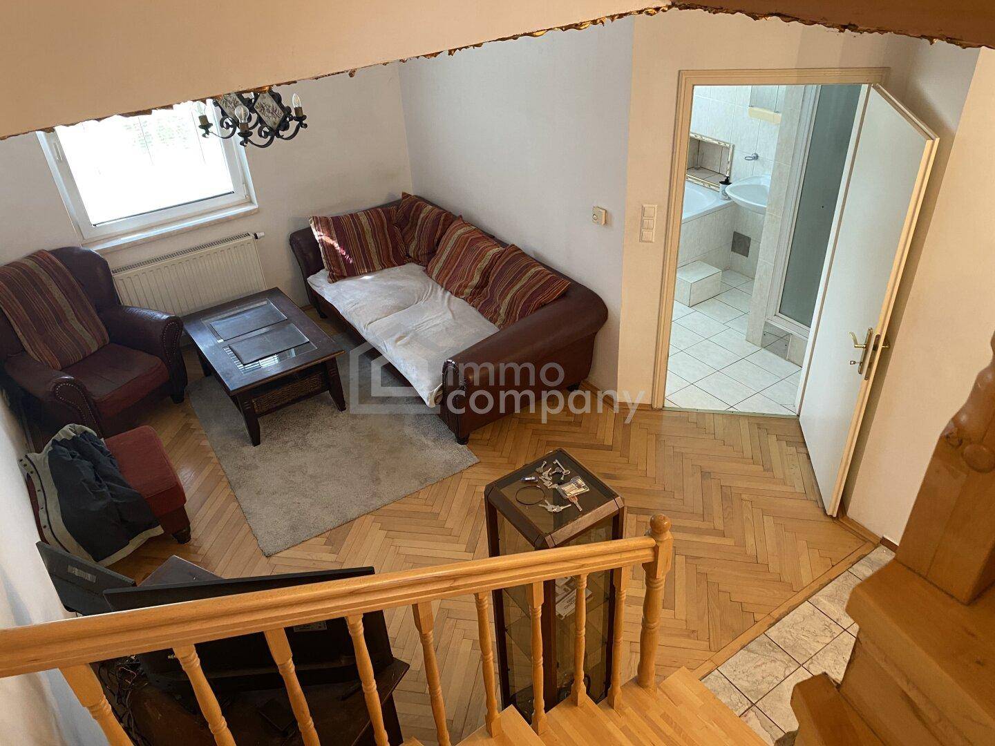Gemütlicher Wohnbereich mit Sofa, Couchtisch und Zugang zu einem Badezimmer.