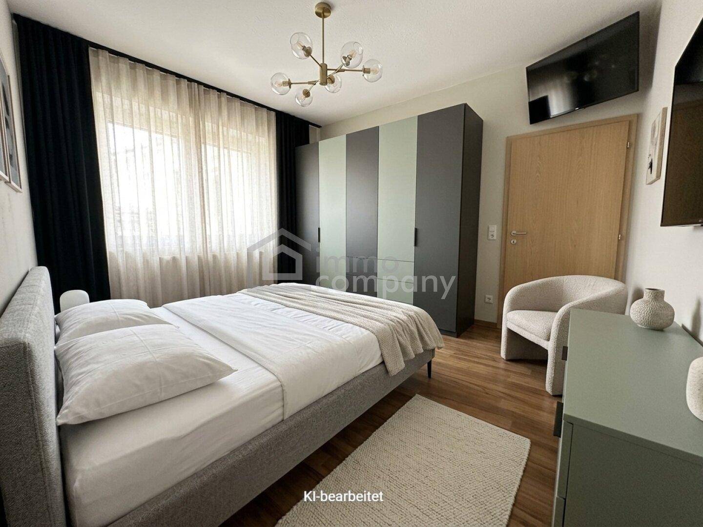 Modernes Schlafzimmer mit Doppelbett, Kleiderschrank und einem an der Wand montierten Fernseher.
