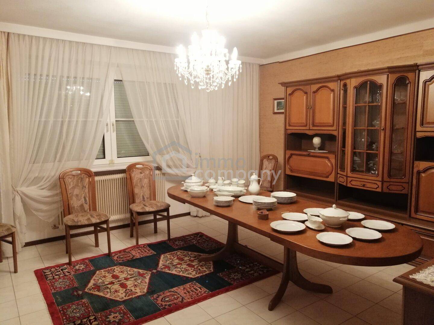 Traditionelles Esszimmer mit antikem Holztisch, Kronleuchter und klassischem Mobiliar.