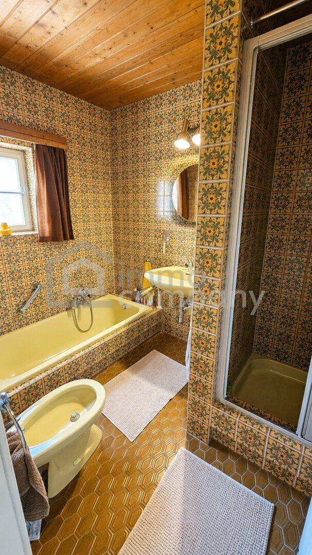 Badezimmer im 80er-Jahre-Stil mit Badewanne, Dusche und Bidet.