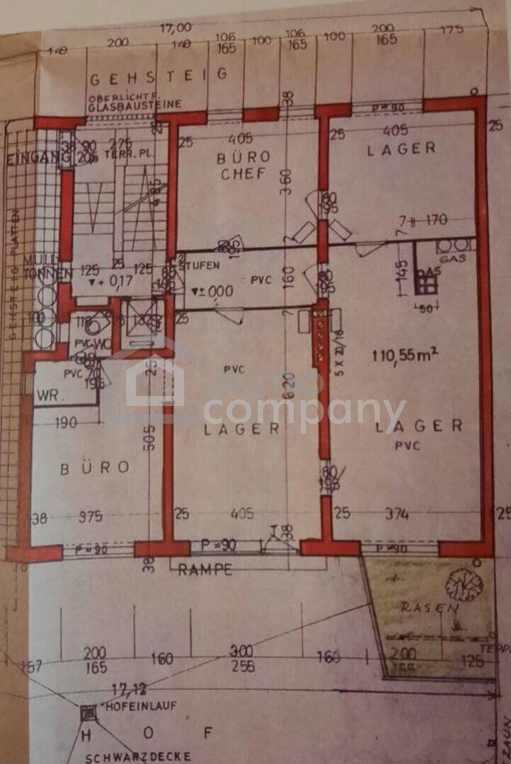 Grundrissplan eines Gewerbeobjekts mit Büros, Lagerräumen, Eingangsbereich und einer Rampe, inklusive Außenbereich mit Rasen.