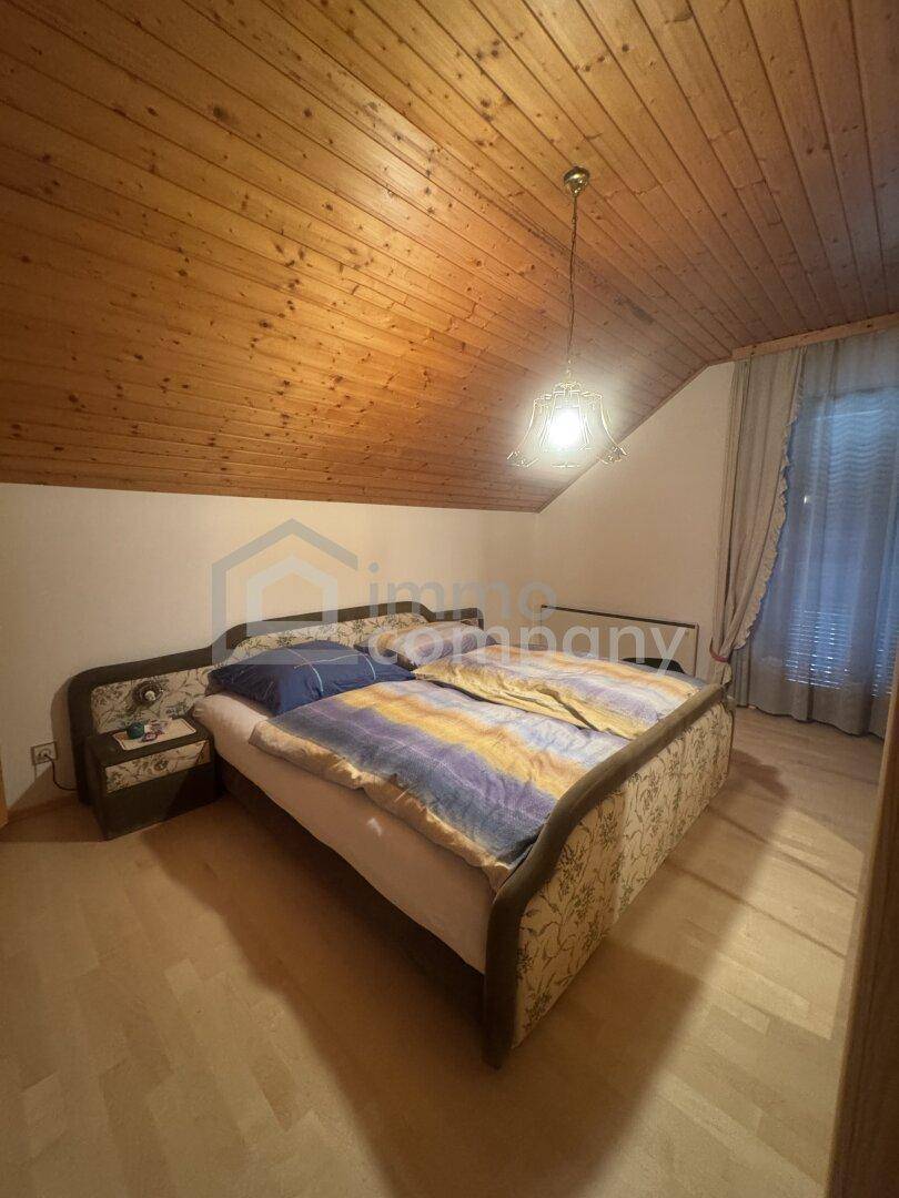 Schlafzimmer mit Holzbett, Holzdecke und Holzboden, gemütlich und rustikal.