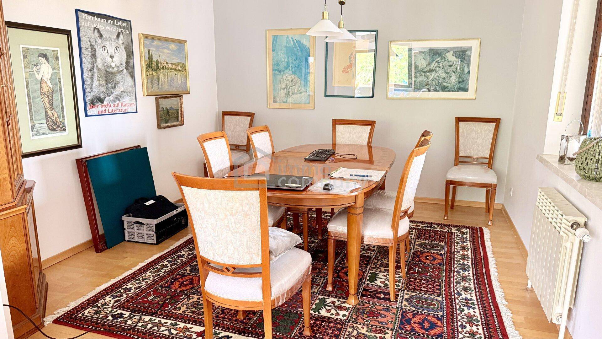 Gemütlicher Essbereich mit Holztisch, passenden Stühlen und einem traditionellen Teppich.