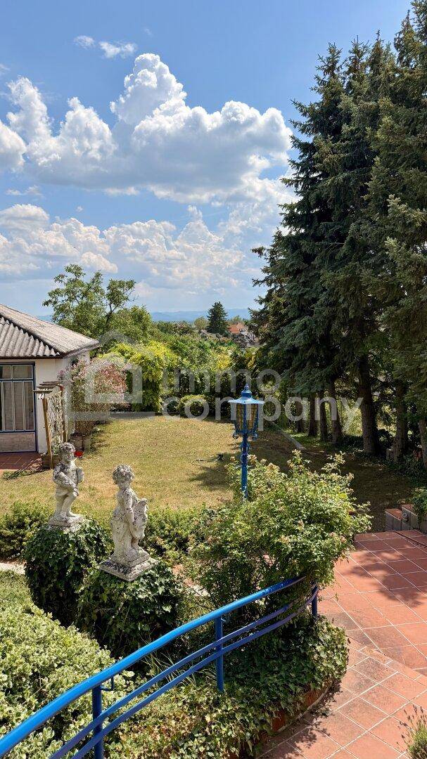 Gepflegter Gartenbereich mit Statuen, Rasen und einem weiten Blick in die Ferne.