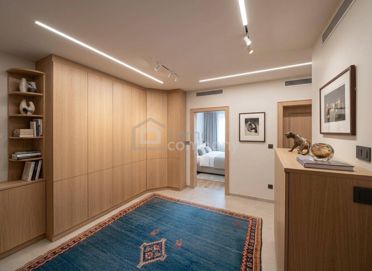 Moderner Flur mit Einbauschränken aus Holz und indirekter Beleuchtung, der zum Schlafzimmer führt.