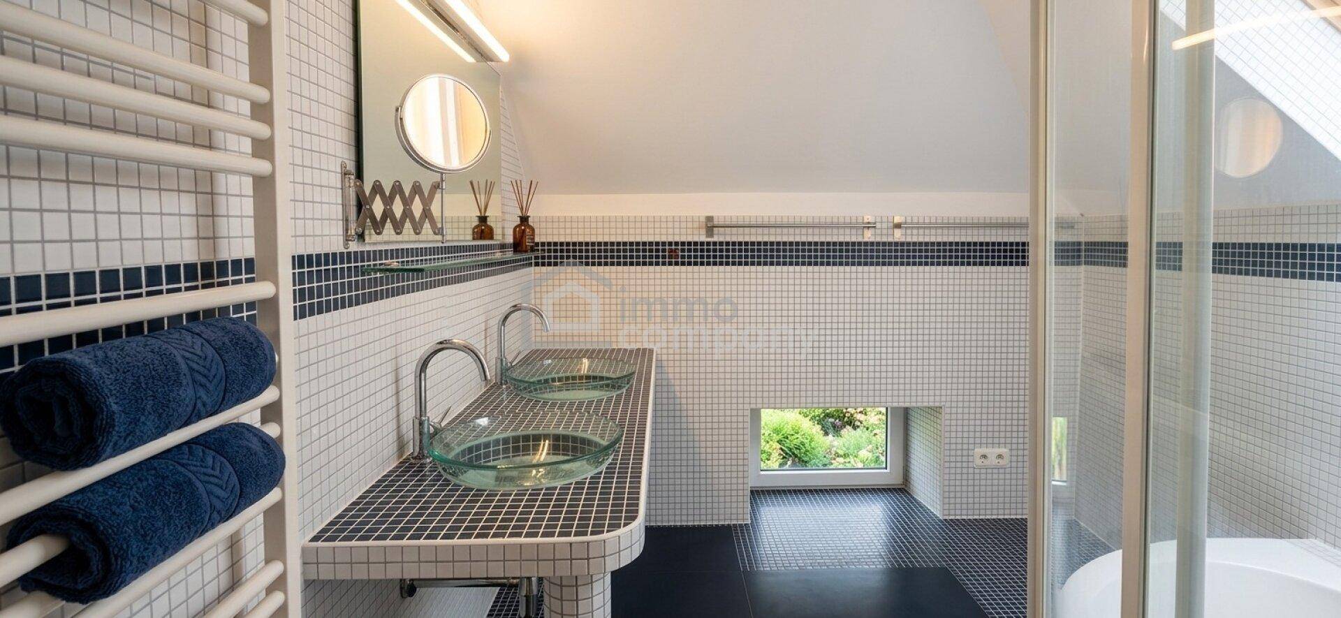 Modernes Badezimmer mit Doppelwaschbecken, Mosaikfliesen und beheiztem Handtuchhalter im Dachgeschoss.